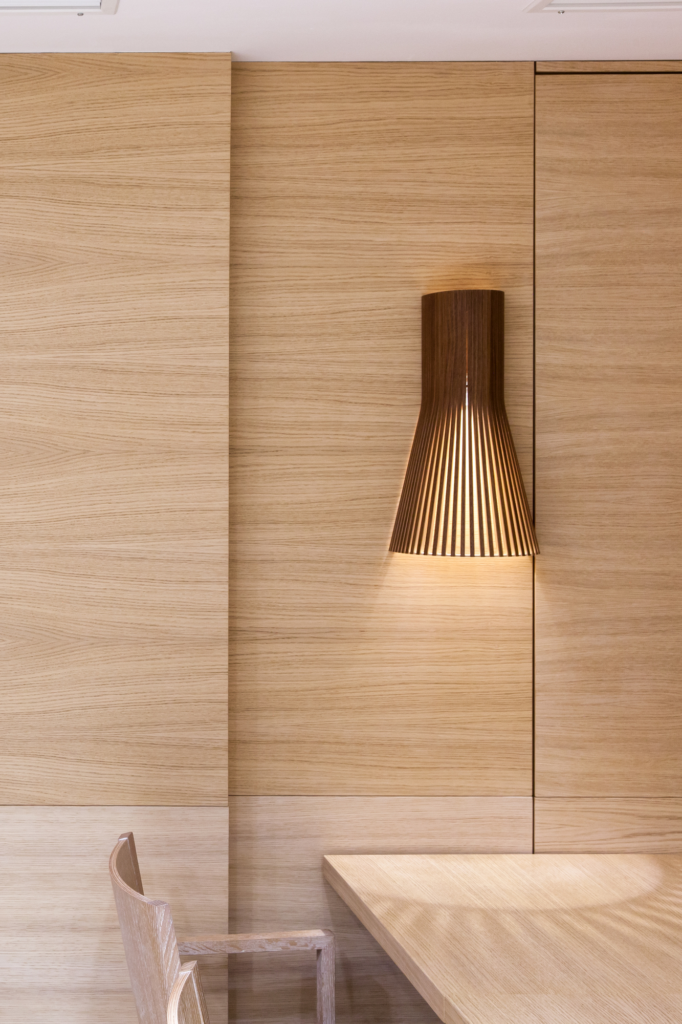 Secto Design Wandleuchte Small 4231 in Schwarz an einer Holzvertäfelung. Designleuchte für Innenräume.