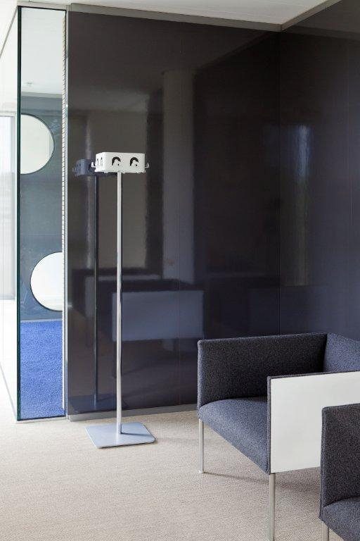 Moderne Garderobenständer mit Haken und grauer Sessel im minimalistischen Interieur Design.