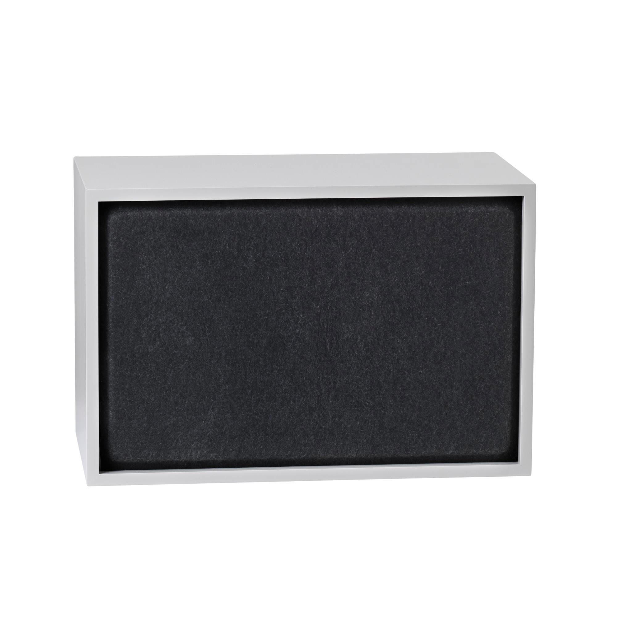 Graues Muuto Stacked Regal mit großer, schwarzer Akustikplatte zur Schallabsorption.