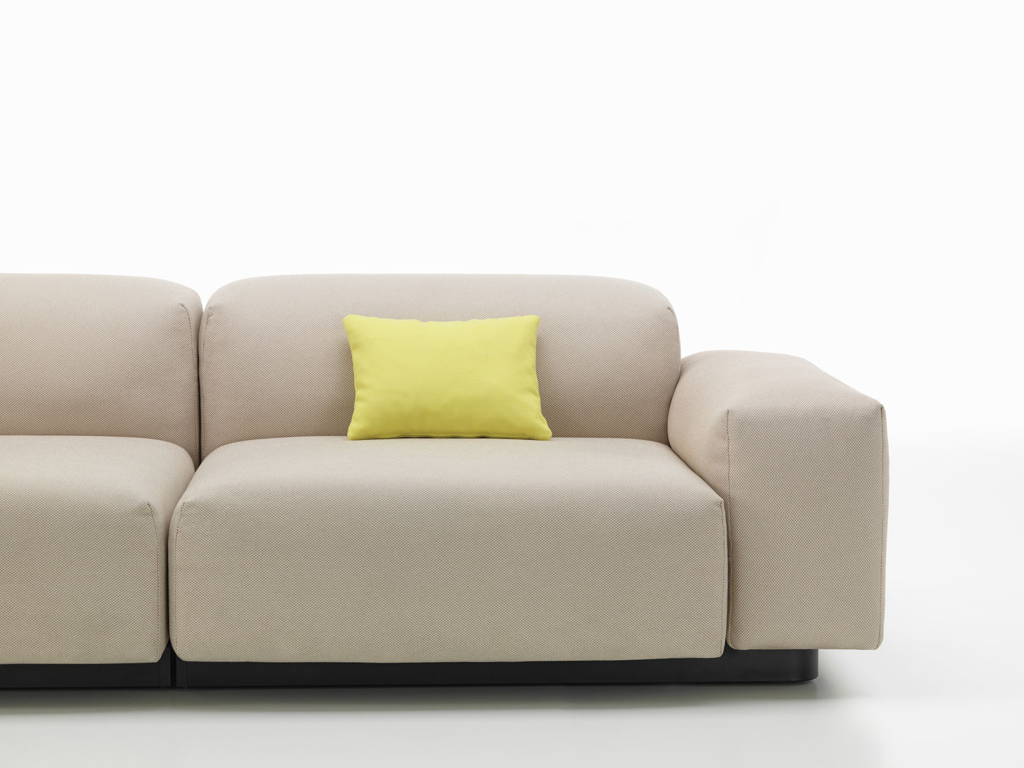 Beiges Sofa mit gelbem Vitra Kissen / Sofakissen für Wohnzimmer und moderne Inneneinrichtung.
