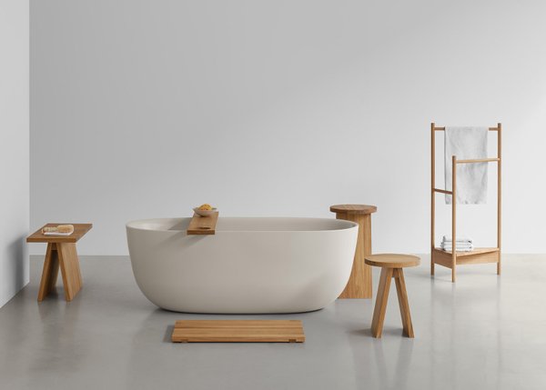 Badezimmer-Interieur mit freistehender Badewanne, Handtuchhalter und e15 Hocker groß EK02 aus massivem Eichenholz.