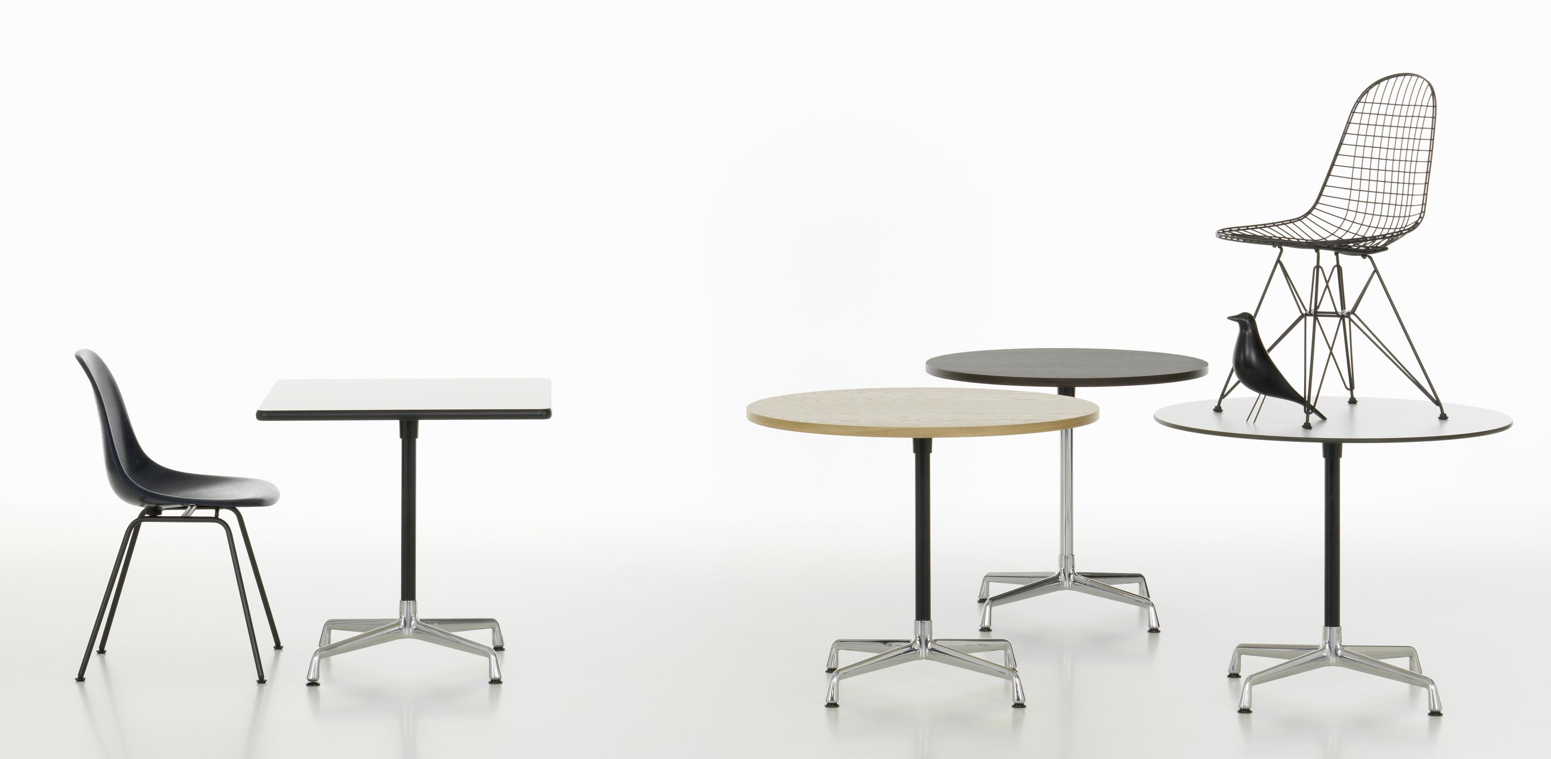 Eames Contract Table von Vitra: Runde und quadratische Tische in verschiedenen Farben mit Stühlen.