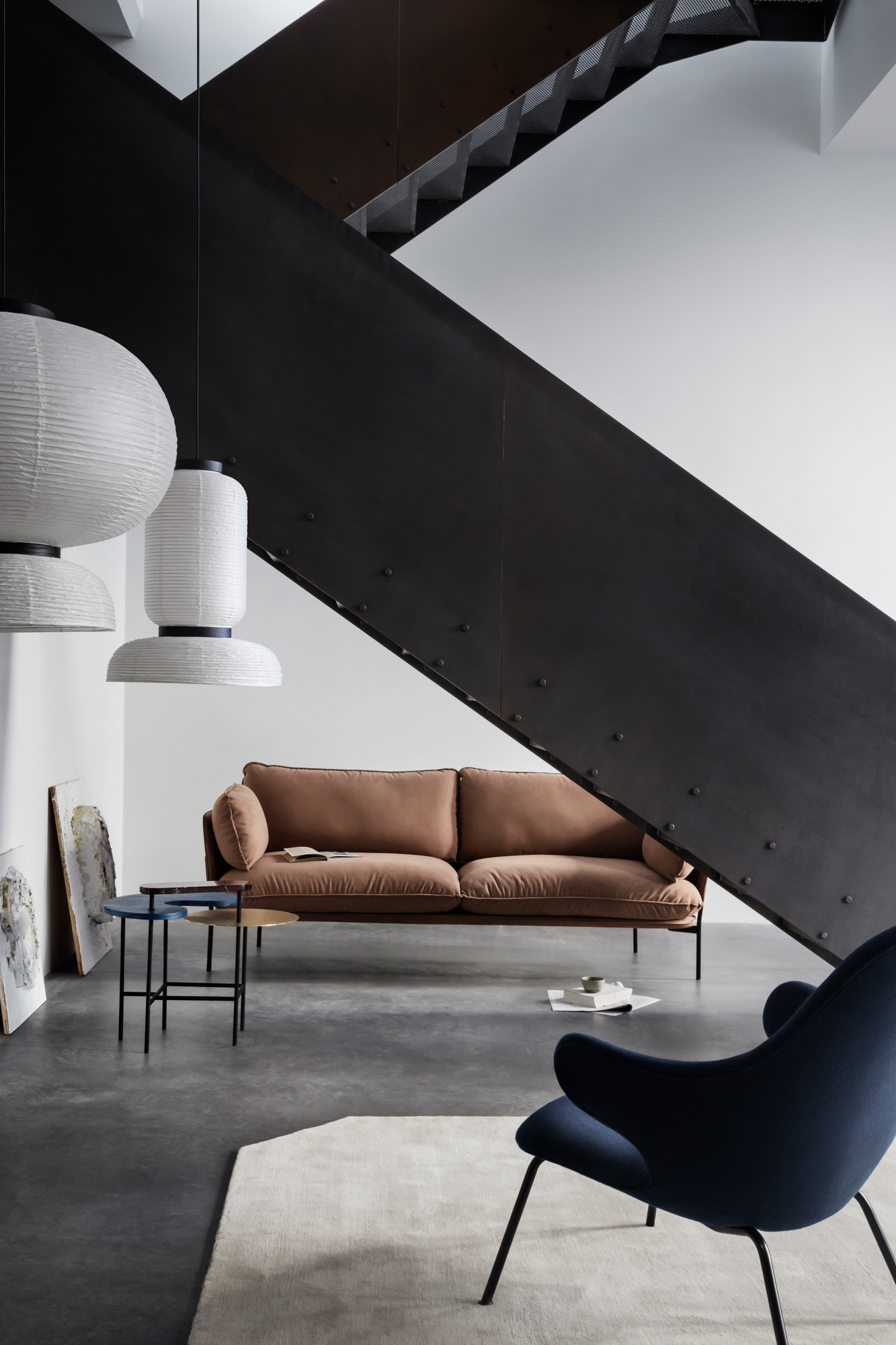 AndTradition Cloud Sofa, braunes 2-Sitzer Sofa im modernen Wohnzimmer mit Treppe und Designermöbeln.