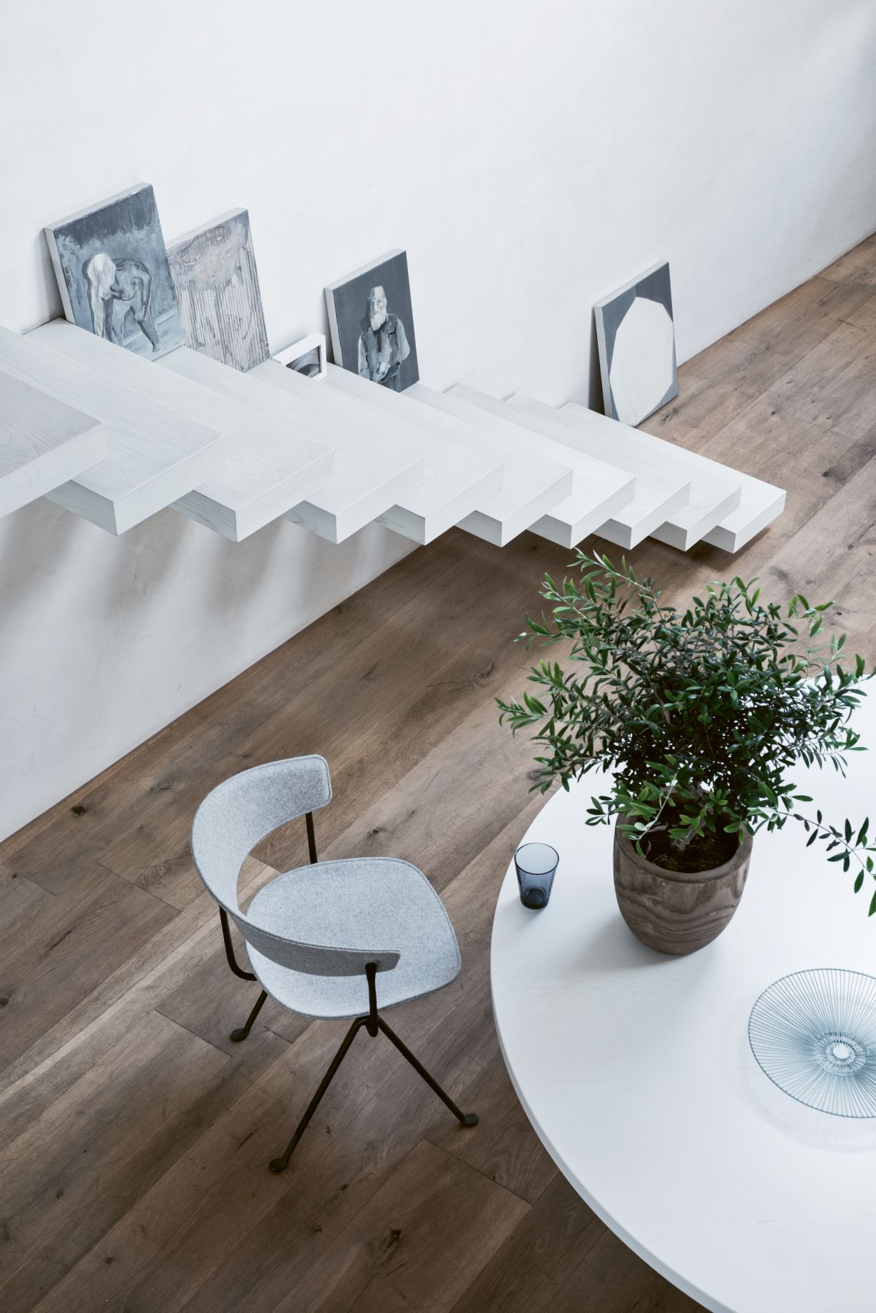 Grauer Officina Stuhl von Magis neben einem weißen Tisch mit Pflanze und Dekoration.