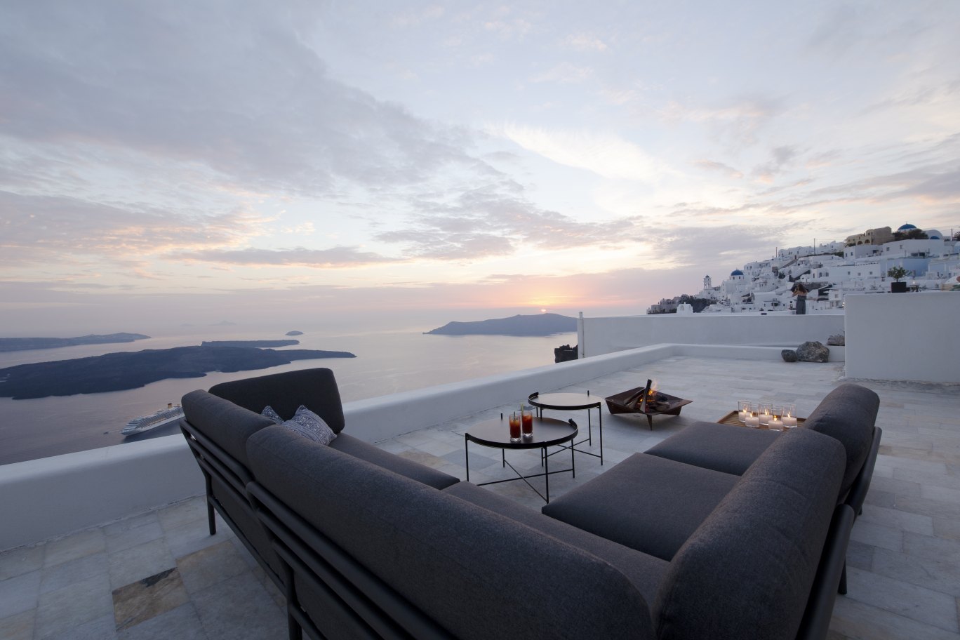 Graues Houe Level Outdoor Sofa auf einer Dachterrasse mit Meerblick bei Sonnenuntergang.