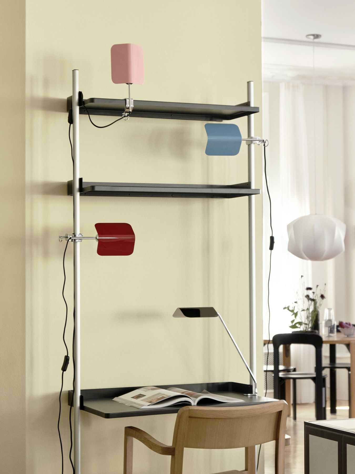 Apex Clip Lamp Klemmleuchte von Hay an Regalsystem mit Schreibtisch, moderne Arbeitsplatzbeleuchtung in Rot, Blau und Rosa.