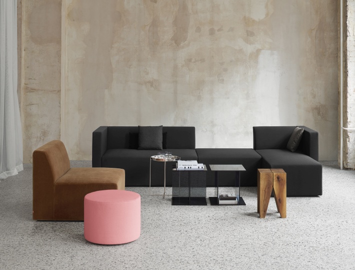 SF06 Kerman Modulsofa von e15 in Schwarz, kombiniert mit Sessel, Hocker und Beistelltischen.