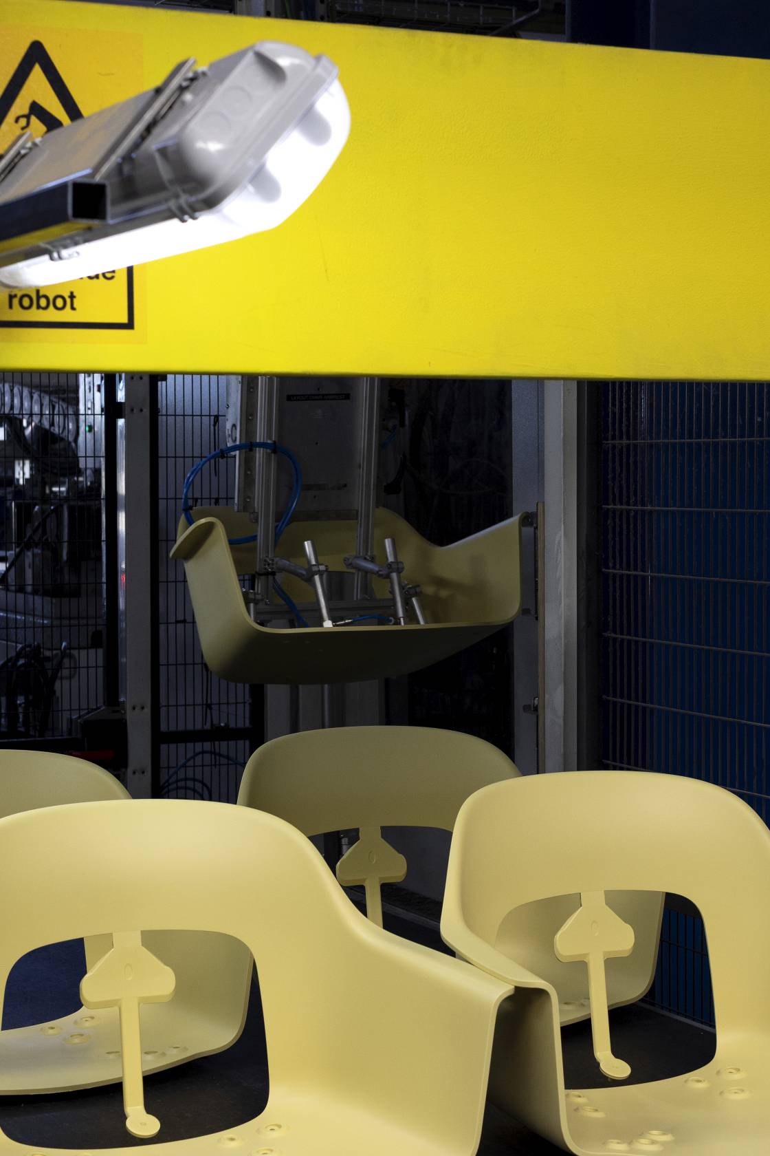 Gelbe Hay Armlehnstühle Layout Armchair 234 in Produktionsumgebung, Fokus auf Sitzschalen und Designelemente.