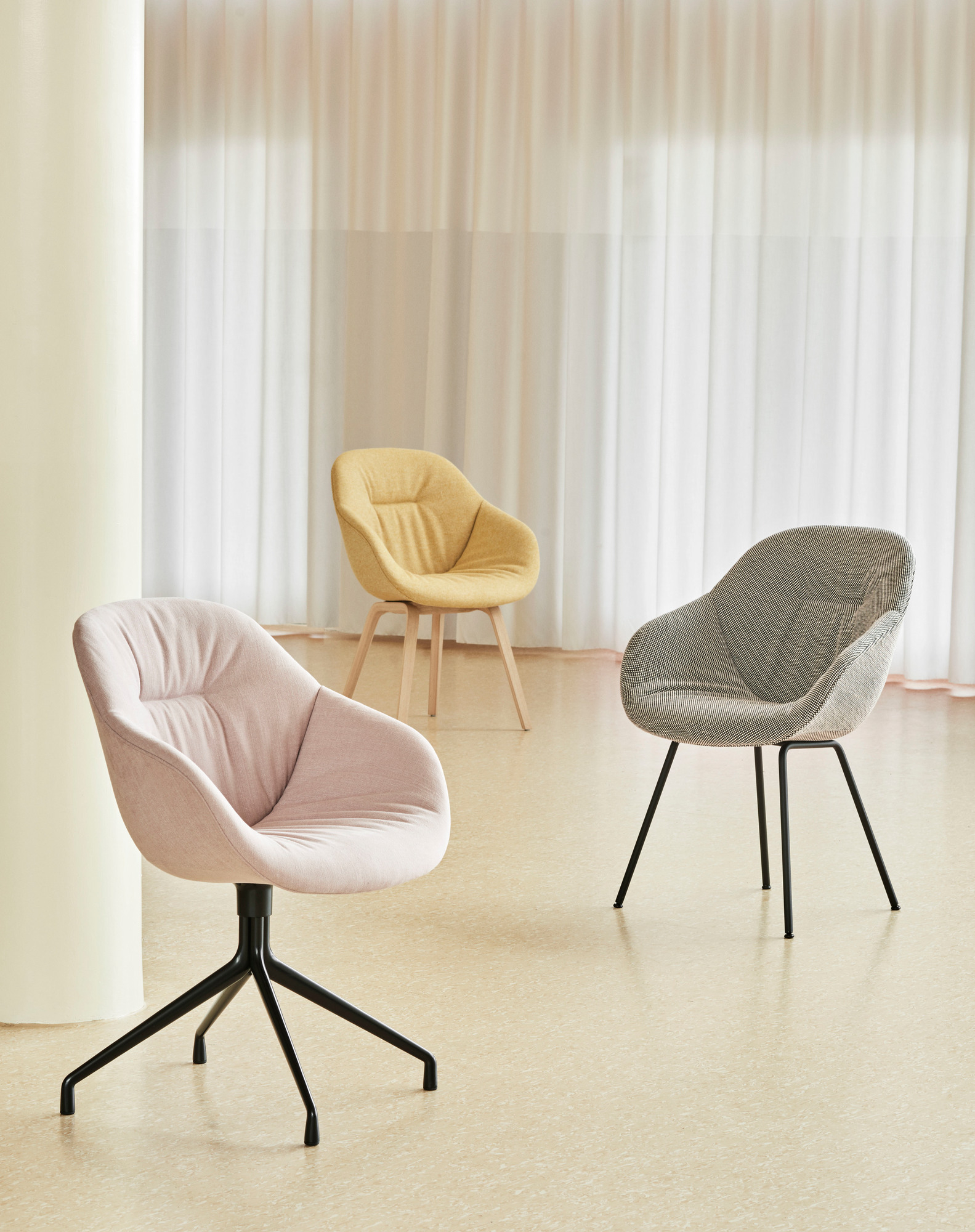 Drei Hay About a Chair AAC123 Soft Duo Stühle in Rosa, Gelb und Grau im Raum.