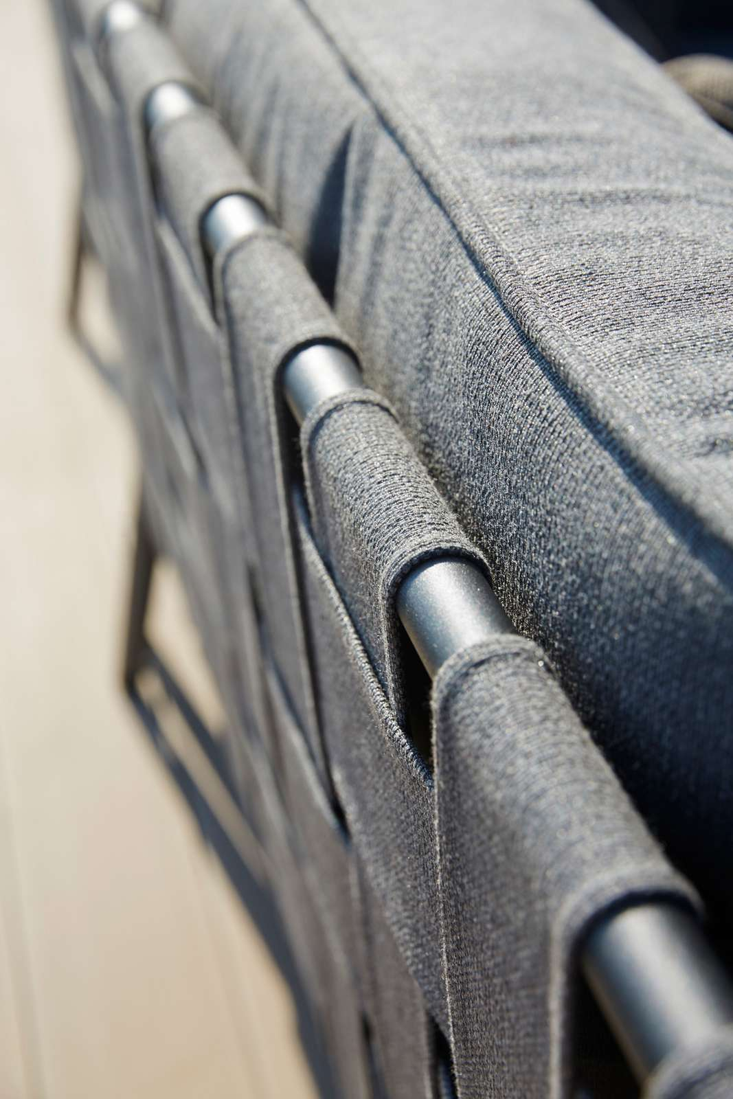 Detailaufnahme des Cane-Line Conic Outdoor Sofas: Graues Textilgewebe und silberne Metallrohre des 2-Sitzer Modulsofas.