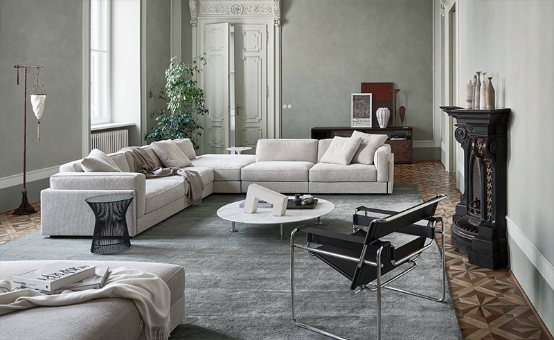 Helles modulares Ecksofa aus Stoff in modernem Wohnzimmer mit Teppich und Designermöbeln.