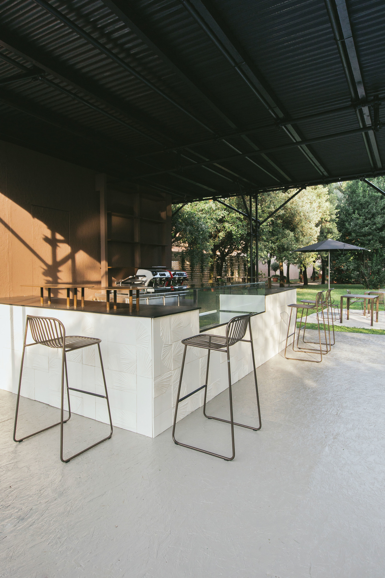 Riviera Barhocker von Emu vor einer Bar im Freien, minimalistisches Design, Metallgestell.