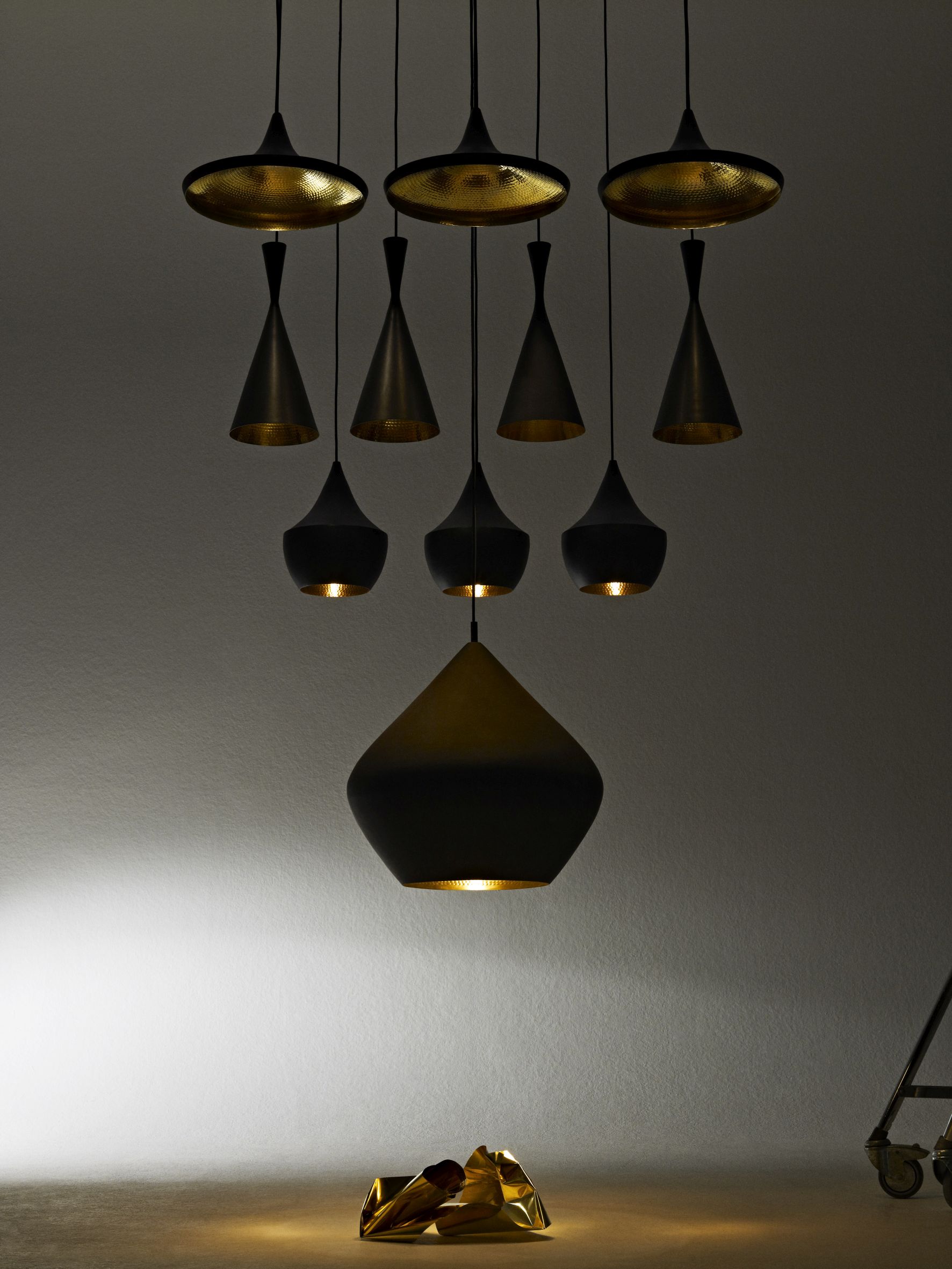 Nahaufnahme der Tom Dixon Beat Pendelleuchten in Schwarz und Gold, modernes Designelement.