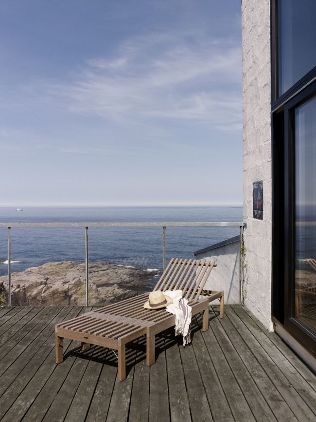 Riviera Sonnenliege aus Holz auf Terrasse mit Meerblick. Outdoor Liege für Garten und Balkon.