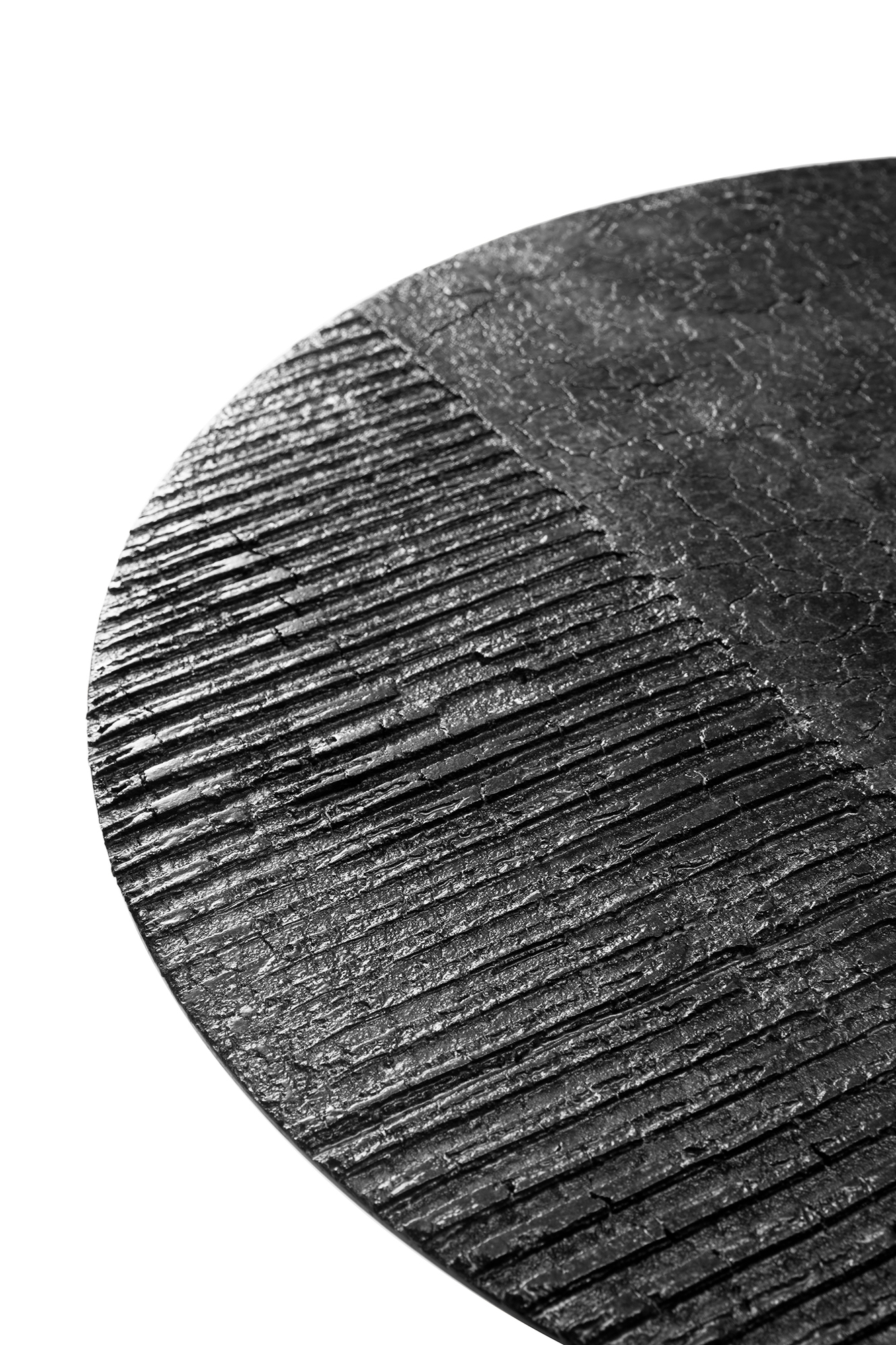 Detailaufnahme der Tischplatte des Luna Couchtisches von Ethnicraft in Lava mit linearer Struktur.