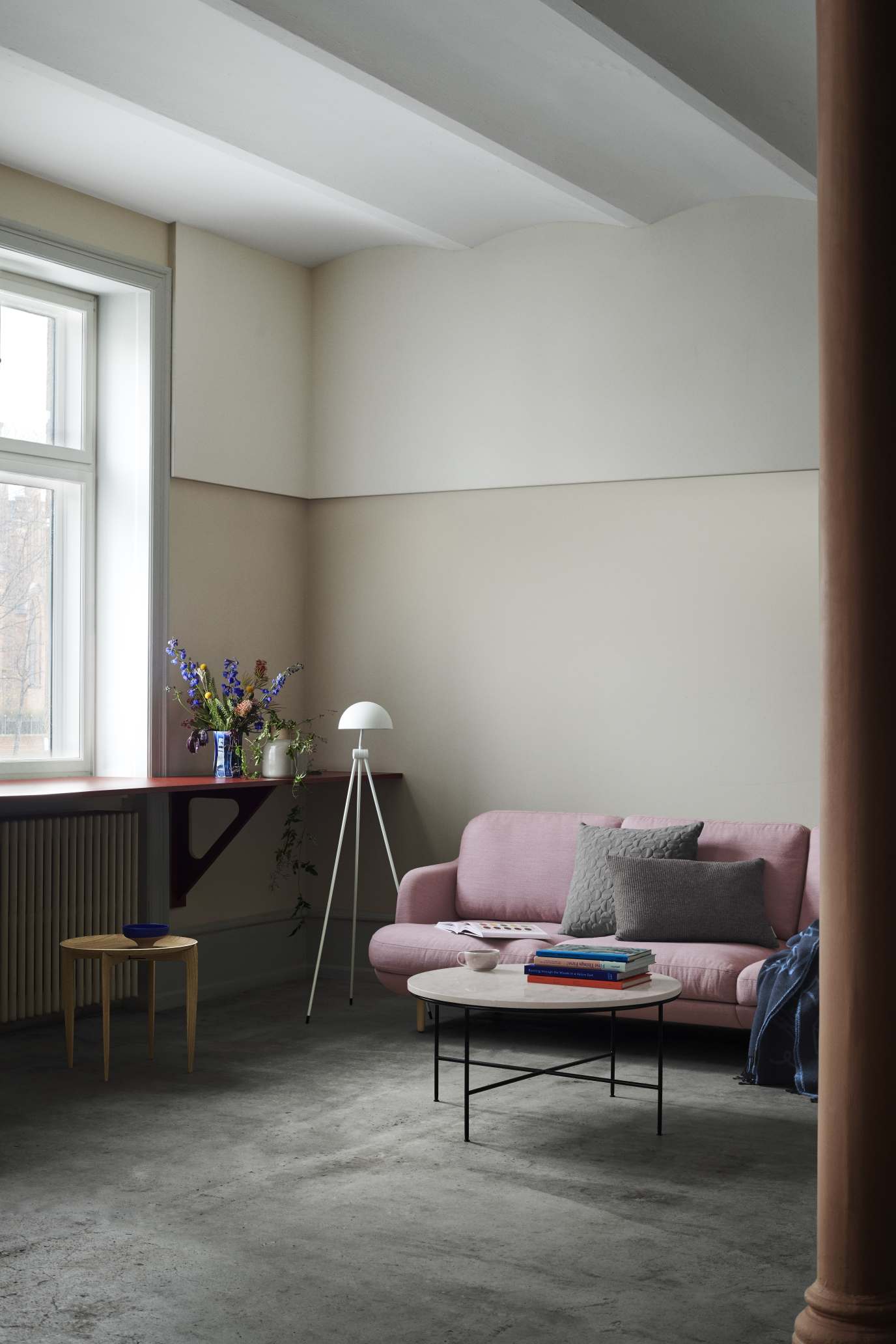 Fritz Hansen Planner Couchtisch im Wohnzimmer mit rosa Sofa, Büchern und stilvoller Dekoration.