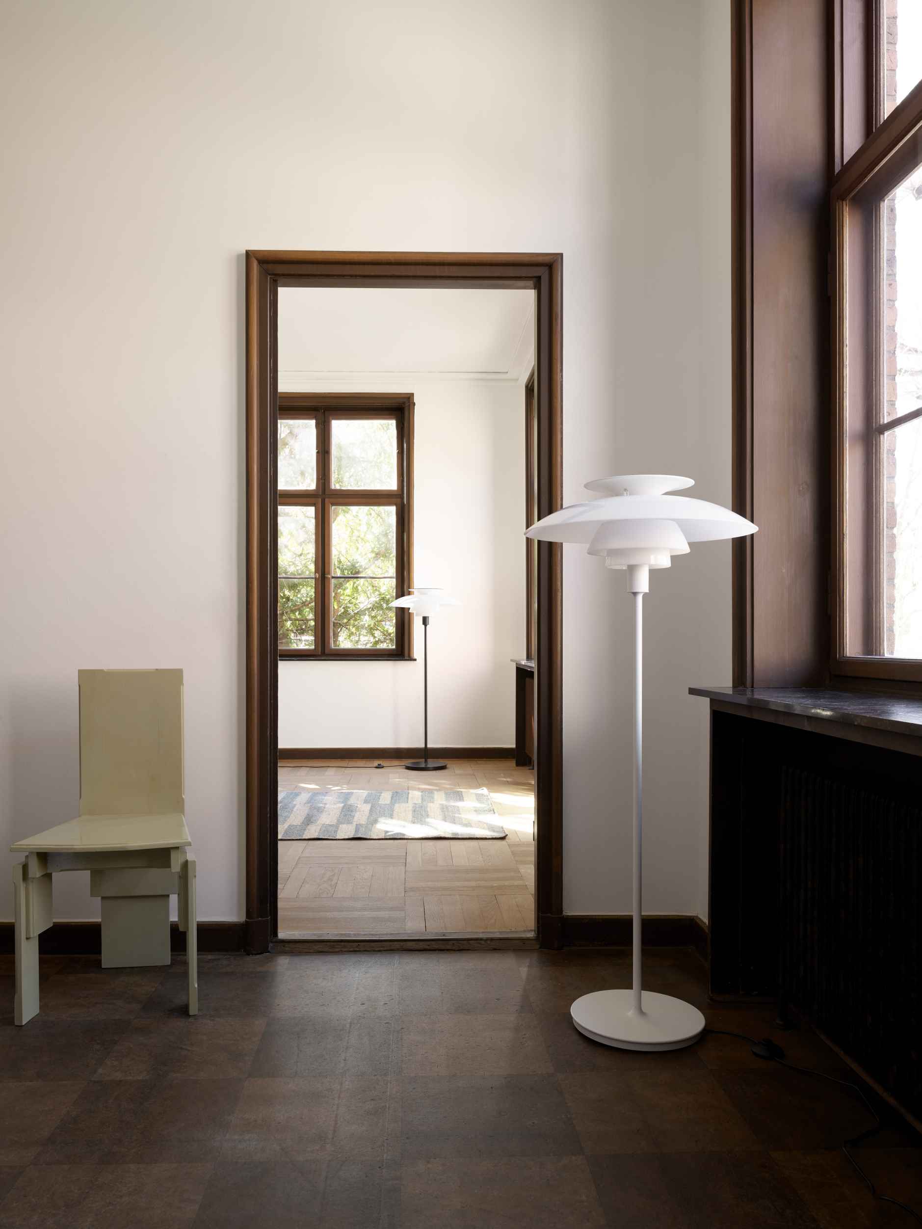 Weiße PH 80 Stehleuchte von Louis Poulsen im Interieur mit Türrahmen und Fenster.