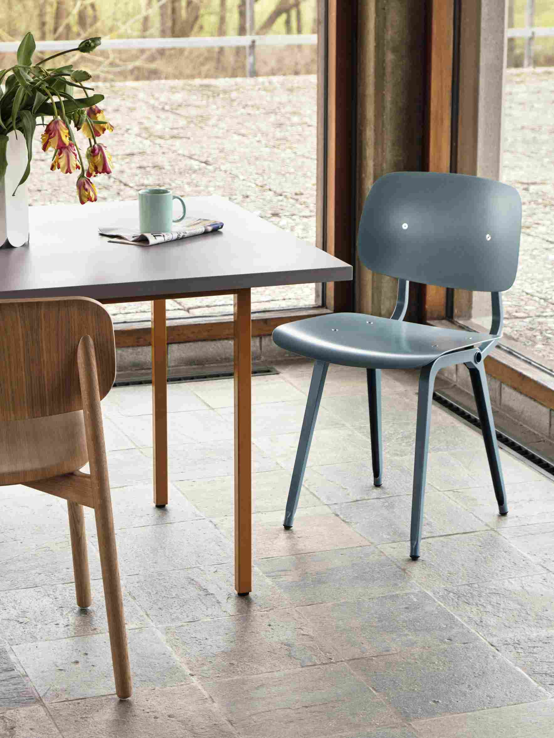 Nahaufnahme eines Esstisches mit Hay Stuhl in blau, modernes Möbeldesign für Esszimmer.