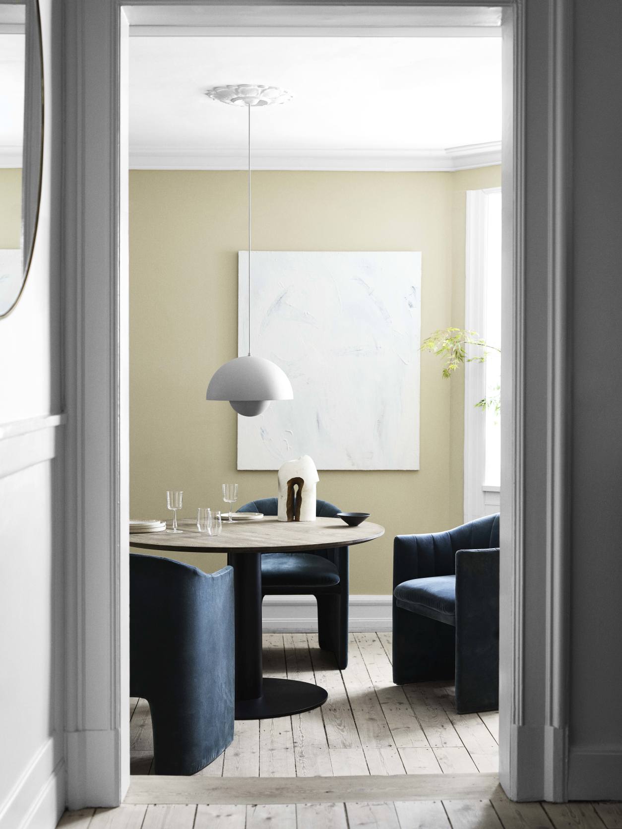 Esszimmer mit Loafer Sessel SC24 von AndTradition in blauem Samt, Holztisch und moderner Pendelleuchte.