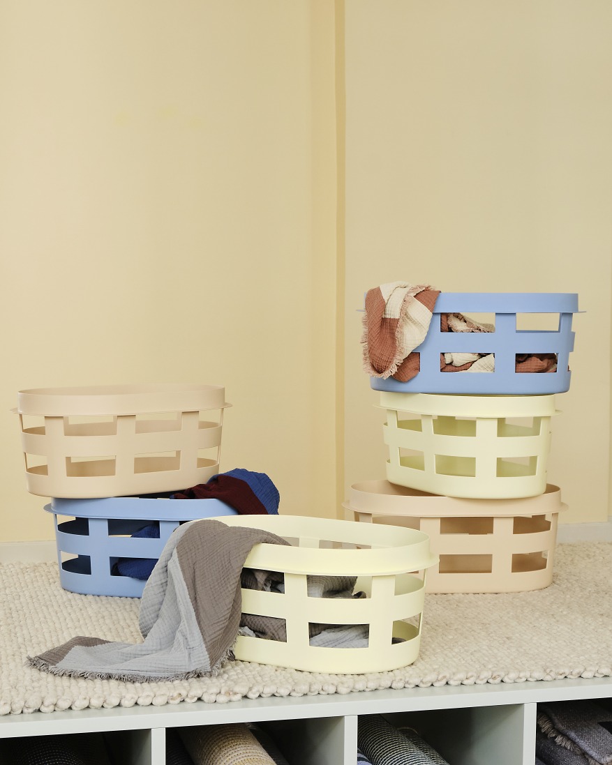 Mehrere Hay Laundry Basket Wäschekörbe S RECYCLED in Soft Blau, Beige und Gelb gestapelt.