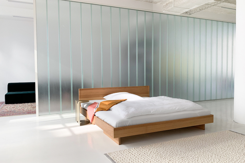 ZIANS Bett Large aus Holz mit Kopfteil und weißer Bettwäsche in modernem Schlafzimmer.
