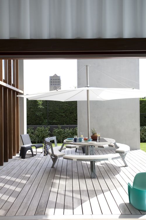 Extremis Gargantua Picknicktisch auf Terrasse mit Sonnenschirm, ideal für Outdoor-Bereiche und geselliges Beisammensein.