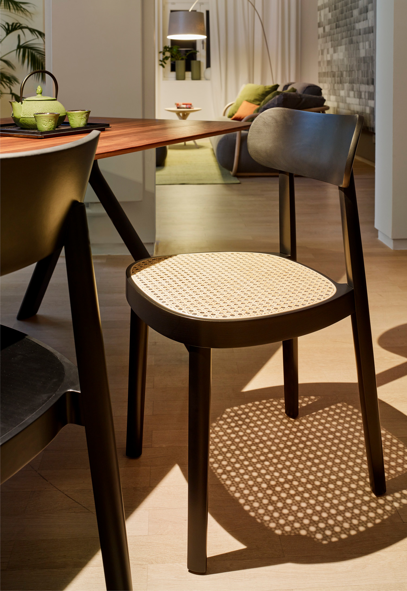 Schwarzer Holzstuhl mit Wiener Geflecht Sitzfläche, Modell 118 von Thonet, im modernen Esszimmer.
