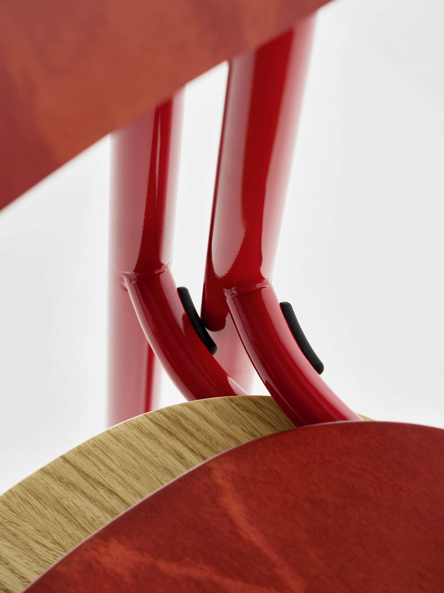 Detailaufnahme des roten Thonet S 243 Stahlrohrstuhls mit Holzelementen, ein Designklassiker für Esszimmer und Wohnbereich.