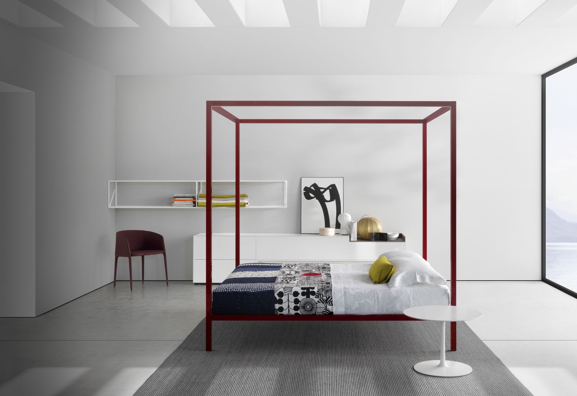 Weißer Flow Low Table Beistelltisch von MDF Italia neben einem modernen Himmelbett in einem hellen Schlafzimmer.