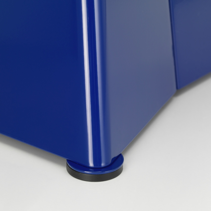 Detailaufnahme vom blauen Vitra Tabouret Métallique Hocker, der einen schwarzen Bodengleiter zeigt.