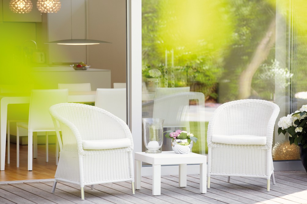 Weißer Romantik Sessel von Jan Kurtz für den Outdoor-Bereich auf einer Holzterrasse.