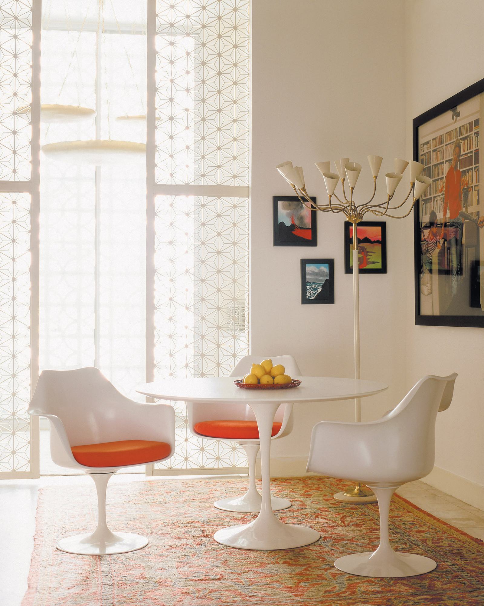 Weißer Saarinen Esstisch mit rundem Untergestell von Knoll International und passenden Armlehnstühlen in einem hellen Esszimmer.
