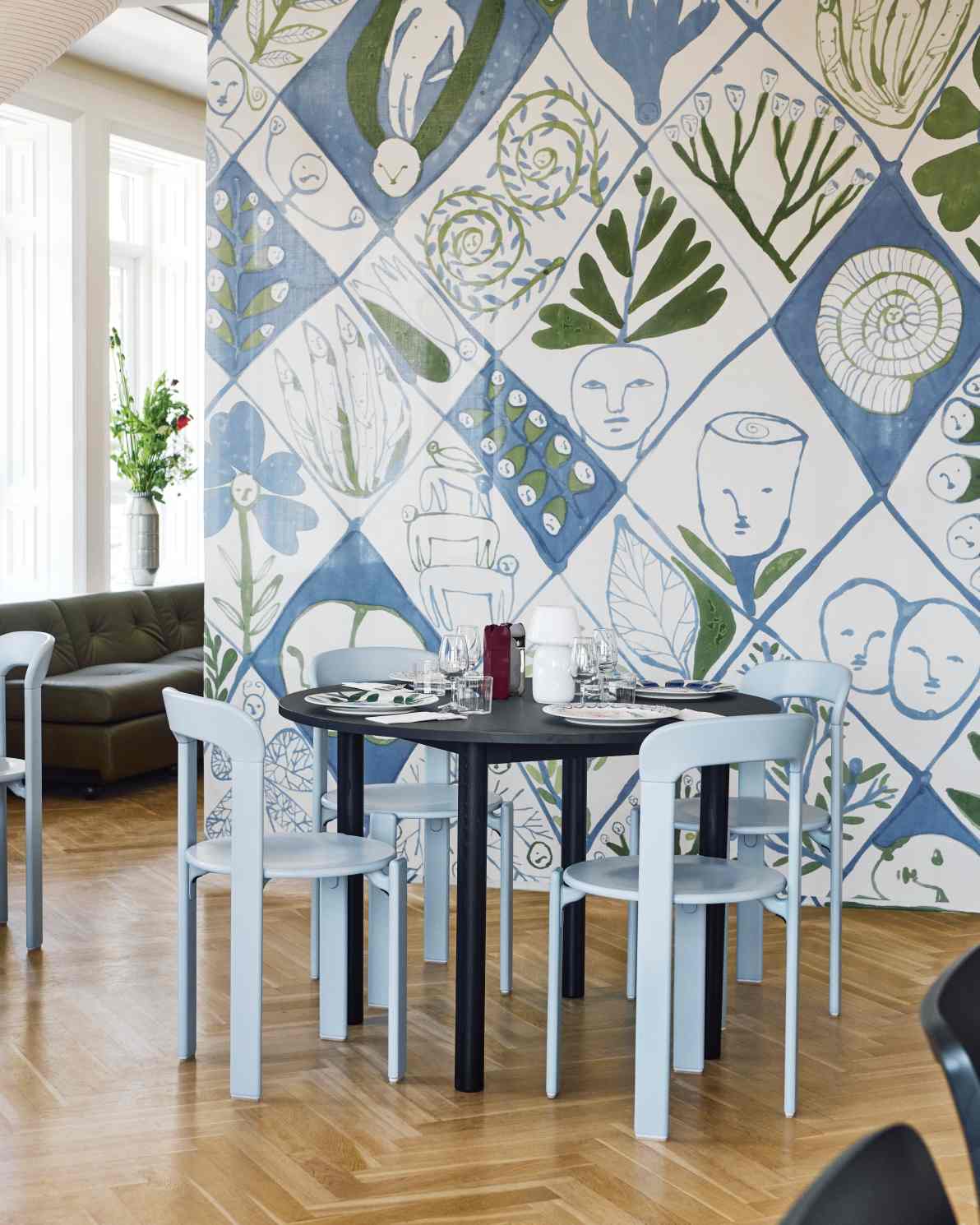 Annex Table Round Esstisch von Hay mit vier hellblauen Stühlen an einem gedeckten Tisch.