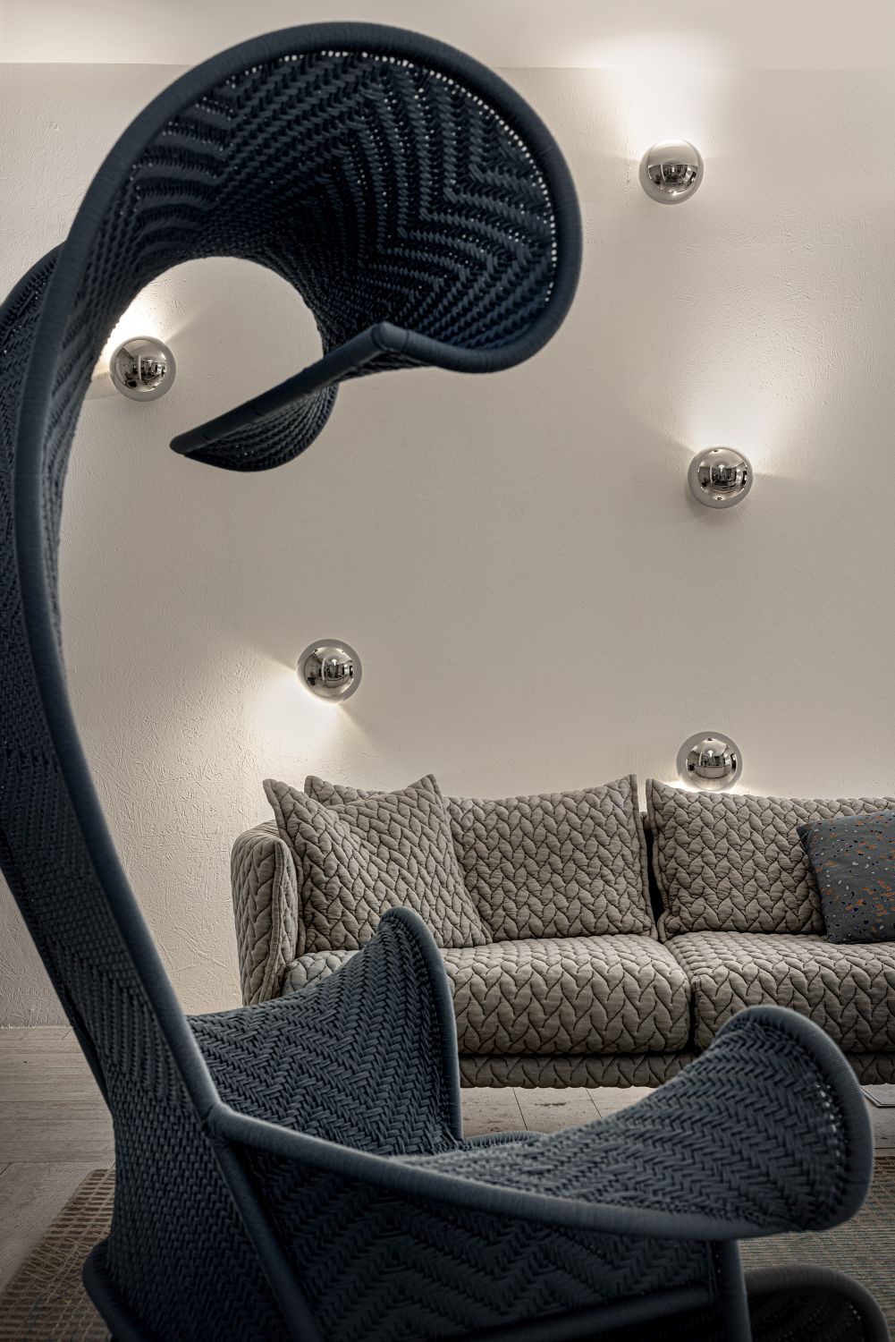 Moderne Sfera Wandleuchten von Catellani & Smith in einem Wohnzimmer mit Sofa und Design-Sessel.