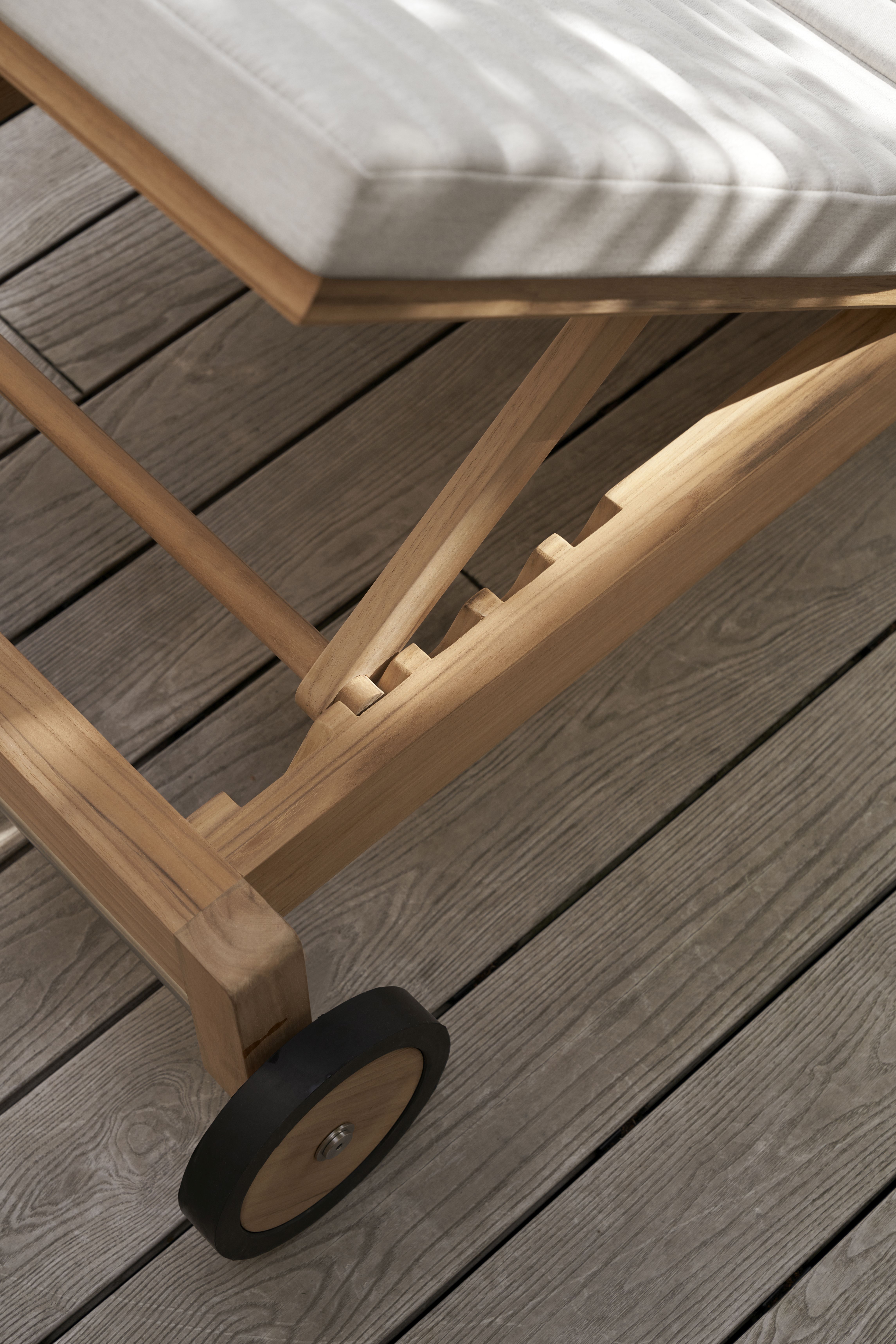 Detailaufnahme der Carl Hansen & Søn AH604 Teak Gartenliege mit Rad und Polster.