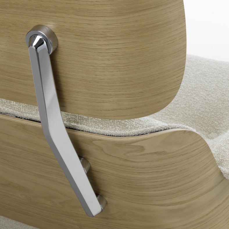 Detailaufnahme Eames Lounge Chair: Armlehne aus hellem Holz und cremefarbenem Stoffbezug, Designklassiker für Wohnzimmer.