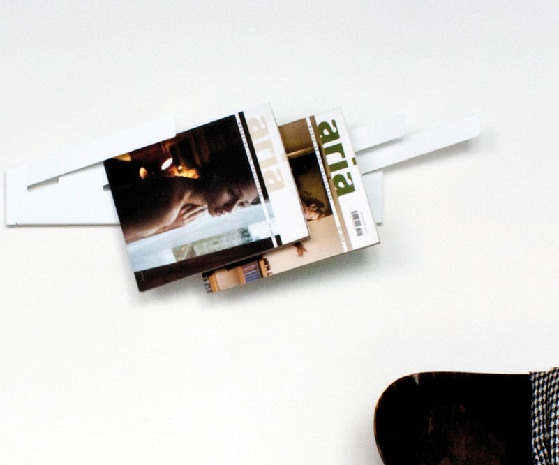 Wandmontierter Magazinständer aus weißem Metall mit zwei Zeitschriften der Marke "aria" in einem minimalistischen Design.