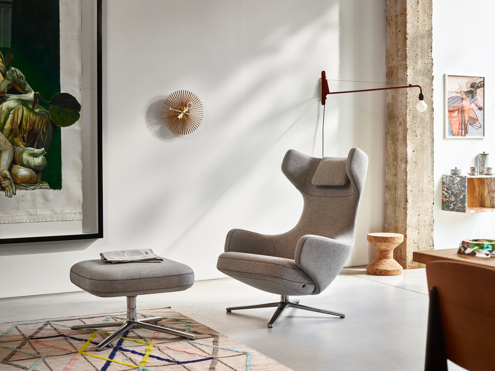 Rote Petite Potence Wandleuchte von Vitra über einem grauen Sessel in modernem Wohnzimmer.