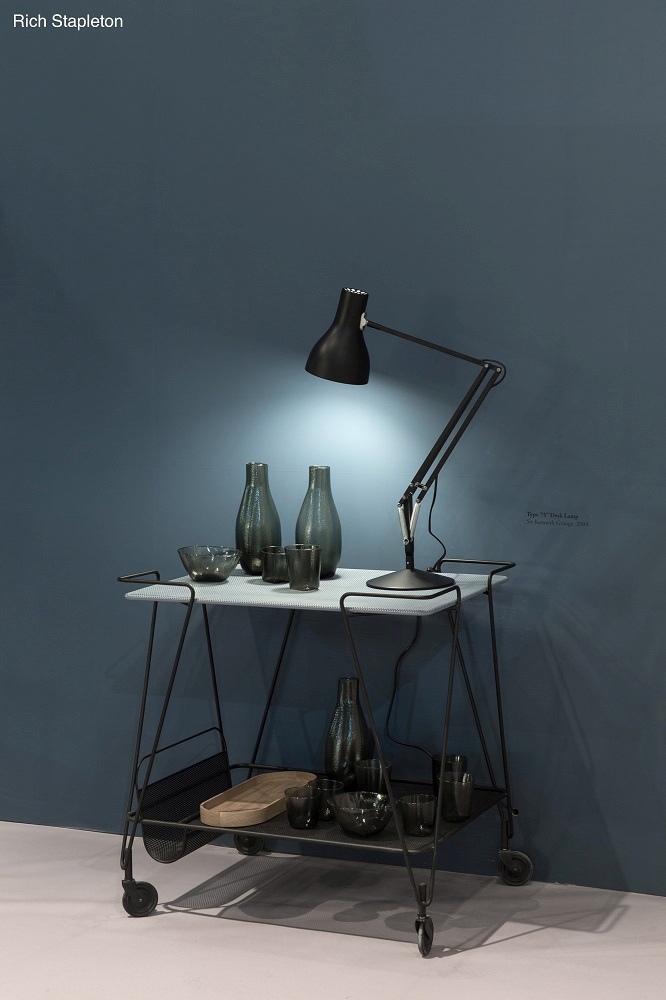 Schwarze Anglepoise Type 75 Schreibtischleuchte auf einem Servierwagen mit Vasen und Gläsern vor einer blauen Wand.