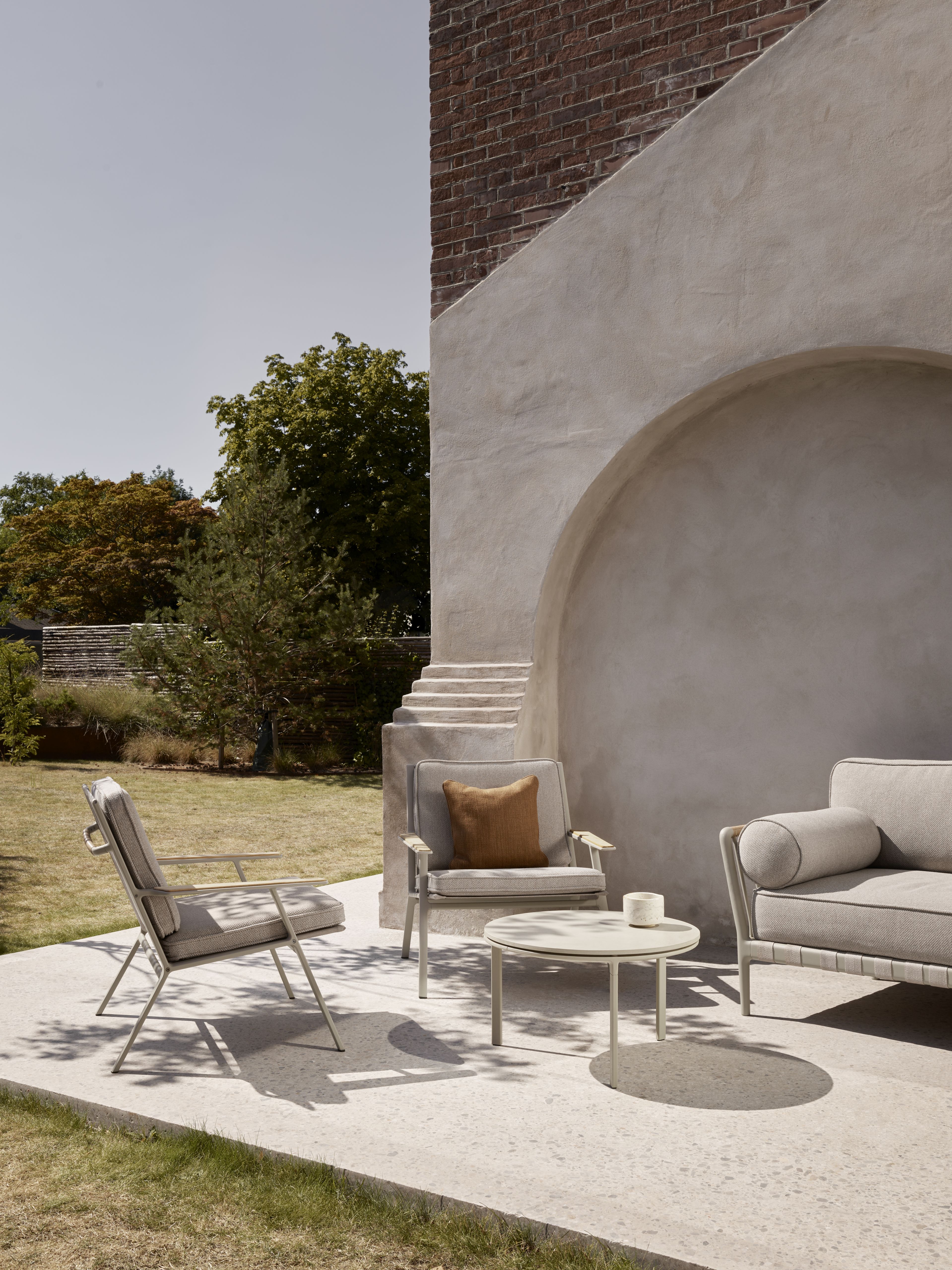 Vipp Open-Air Outdoor Kaffeetisch Ø60 mit Lounge Möbeln auf Terrasse im Garten.