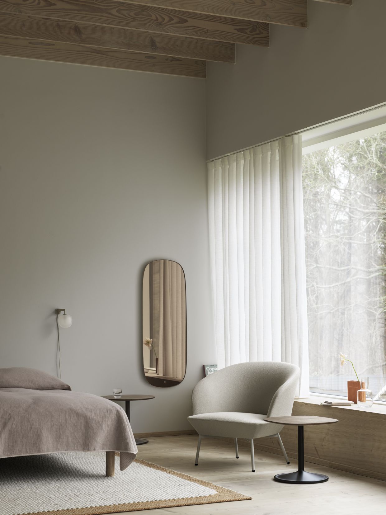 Heller Wohnraum mit Oslo Lounge Chair Sessel von Muuto, Beistelltisch und Spiegel.