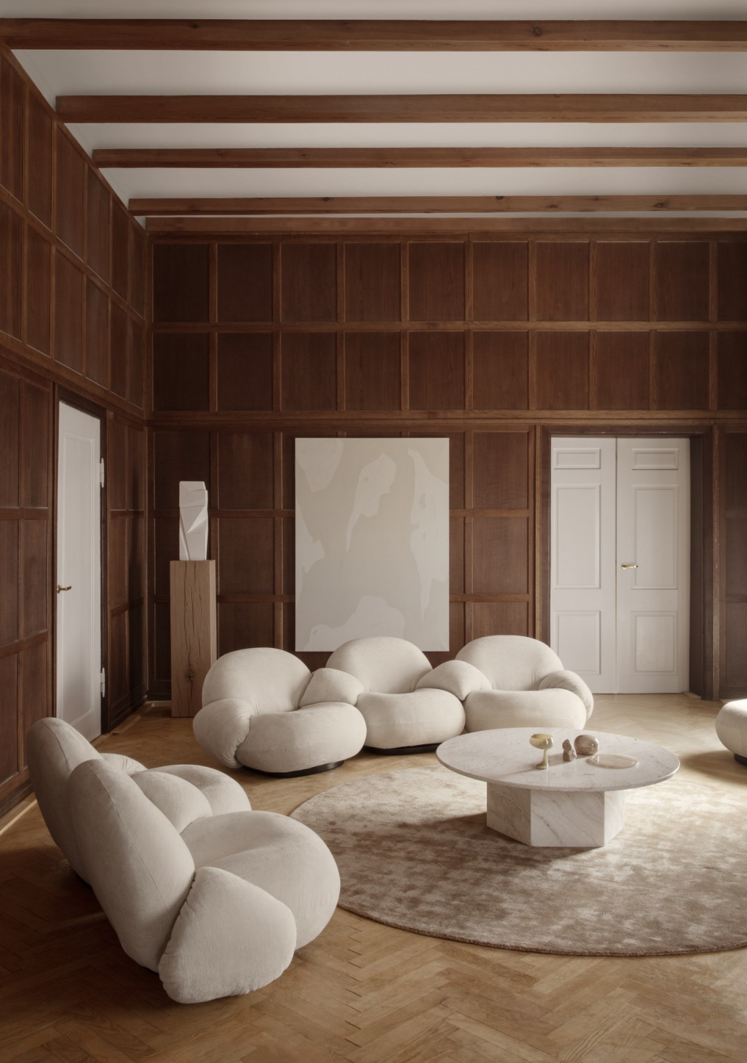 Wohnzimmer-Szene mit dem Epic Coffee Table Couchtisch 110 von Gubi, Marmor-Couchtisch und beigen Sesseln.