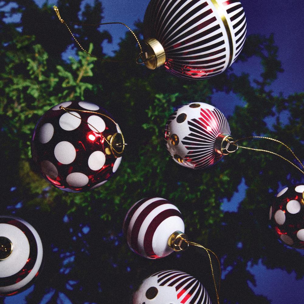 Mehrere Alessi Weihnachtskugeln mit Streifen und Punkten am Weihnachtsbaum, Modell NZ04 2 Delight.