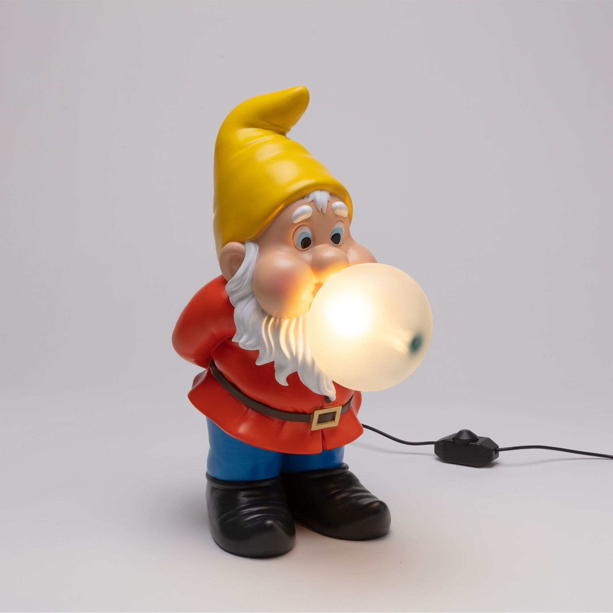 Gummy Snooping Lampe von Seletti: Detailaufnahme eines Gartenzwergs mit gelbem Hut und leuchtender Kaugummi-Blase.