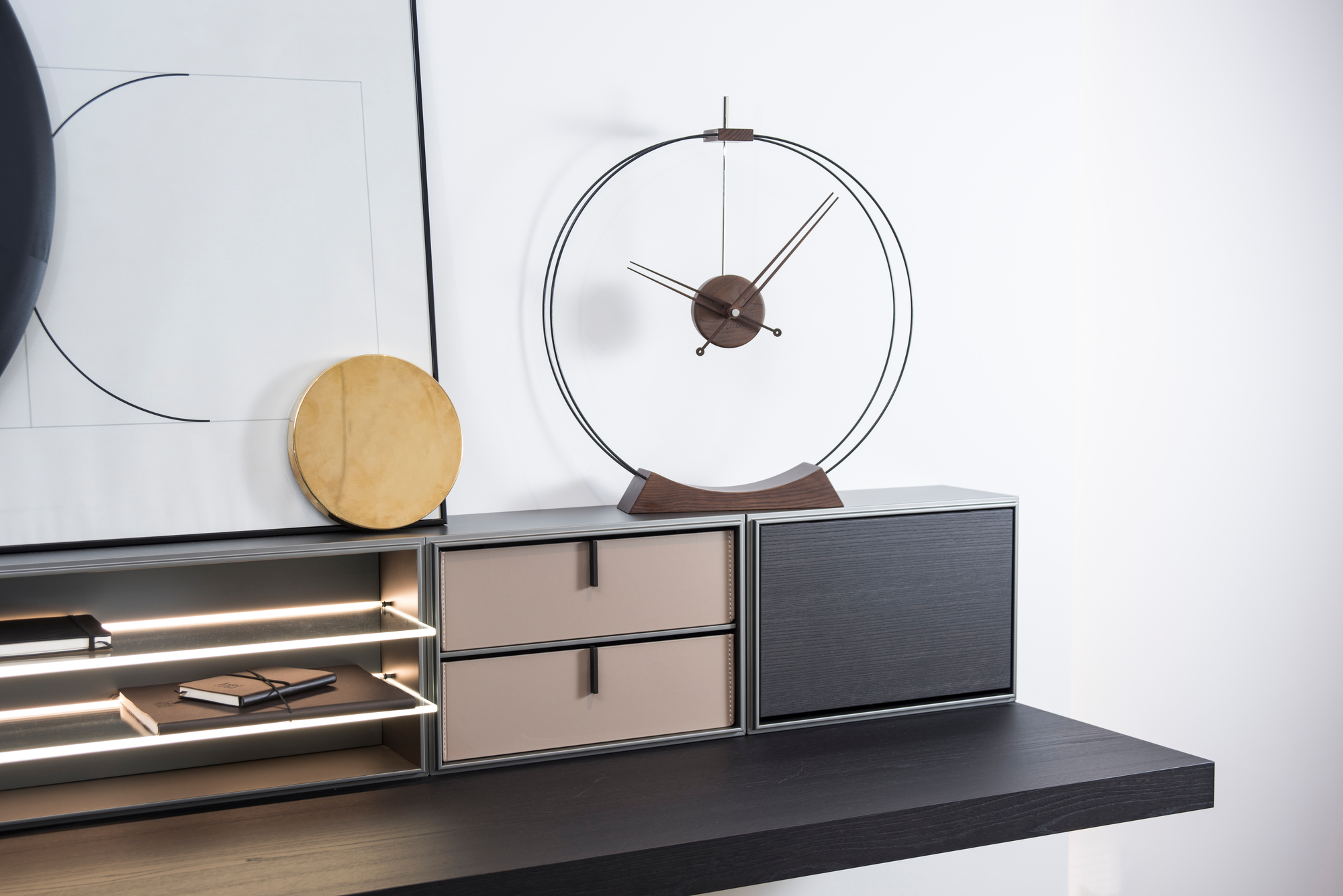 Aire Tischuhr von nomon auf einem Sideboard, modernes Design mit Holzdetails und minimalistischem Zifferblatt.