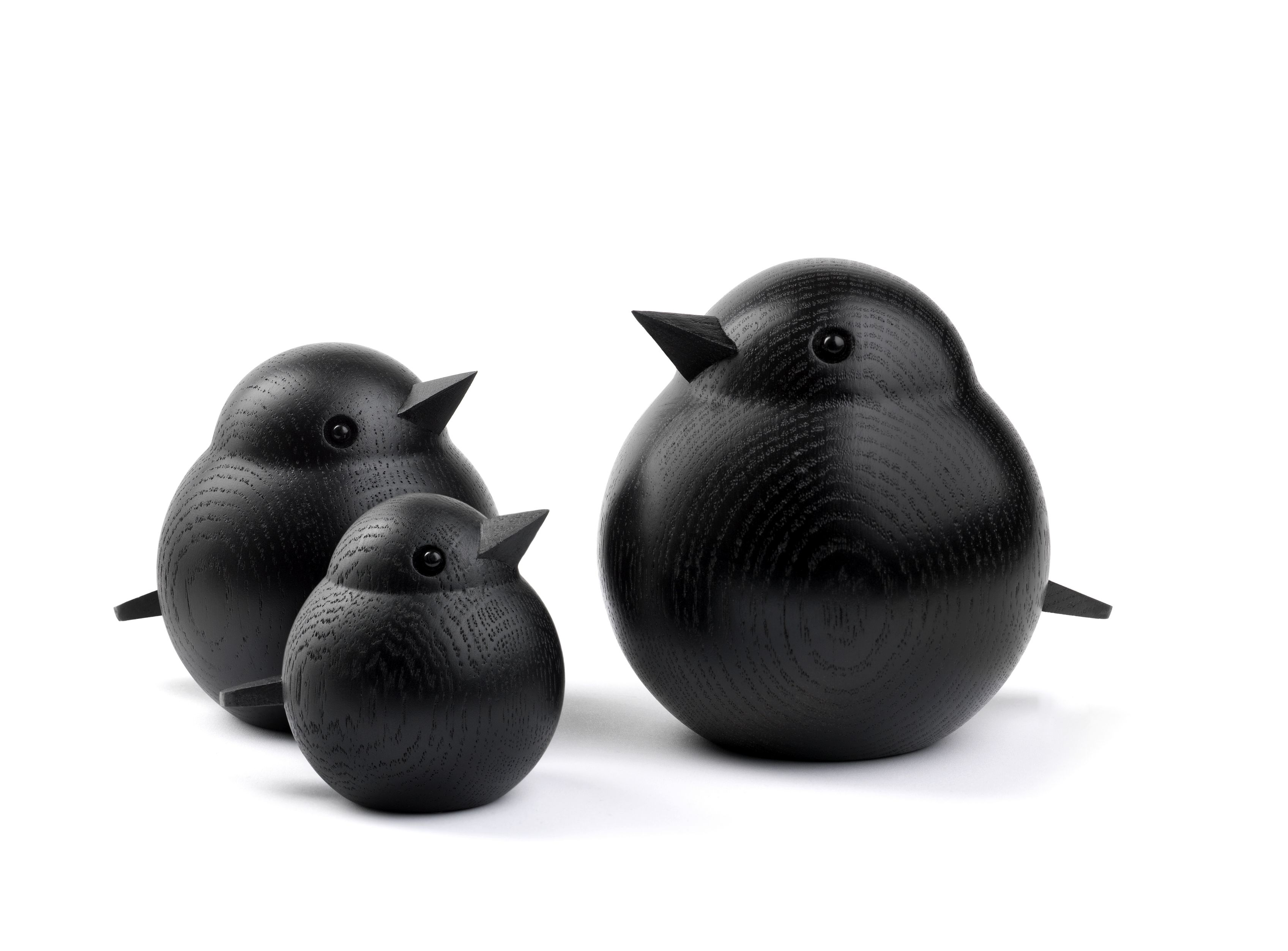 Drei schwarze Holzfiguren, die eine Vogelfamilie darstellen: Papa Sparrow, Mama und Baby.