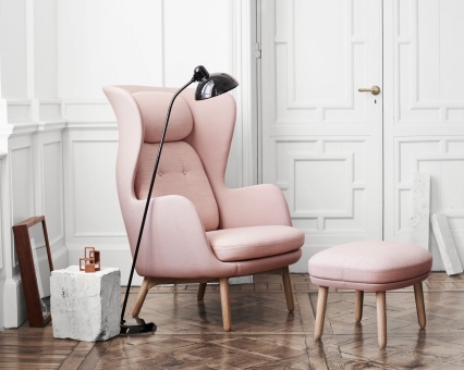 Rosa Ohrensessel mit Hocker und Stehlampe im modernen Wohnzimmer, skandinavisches Design.