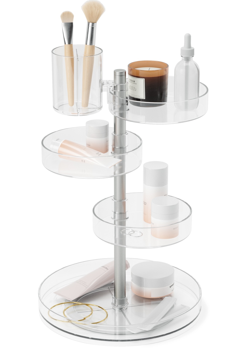 Umbra Pirouette Organizer mit Kosmetikprodukten, Make-up-Pinsel, Kerze und Schmuck auf vier transparenten, drehbaren Ebenen.