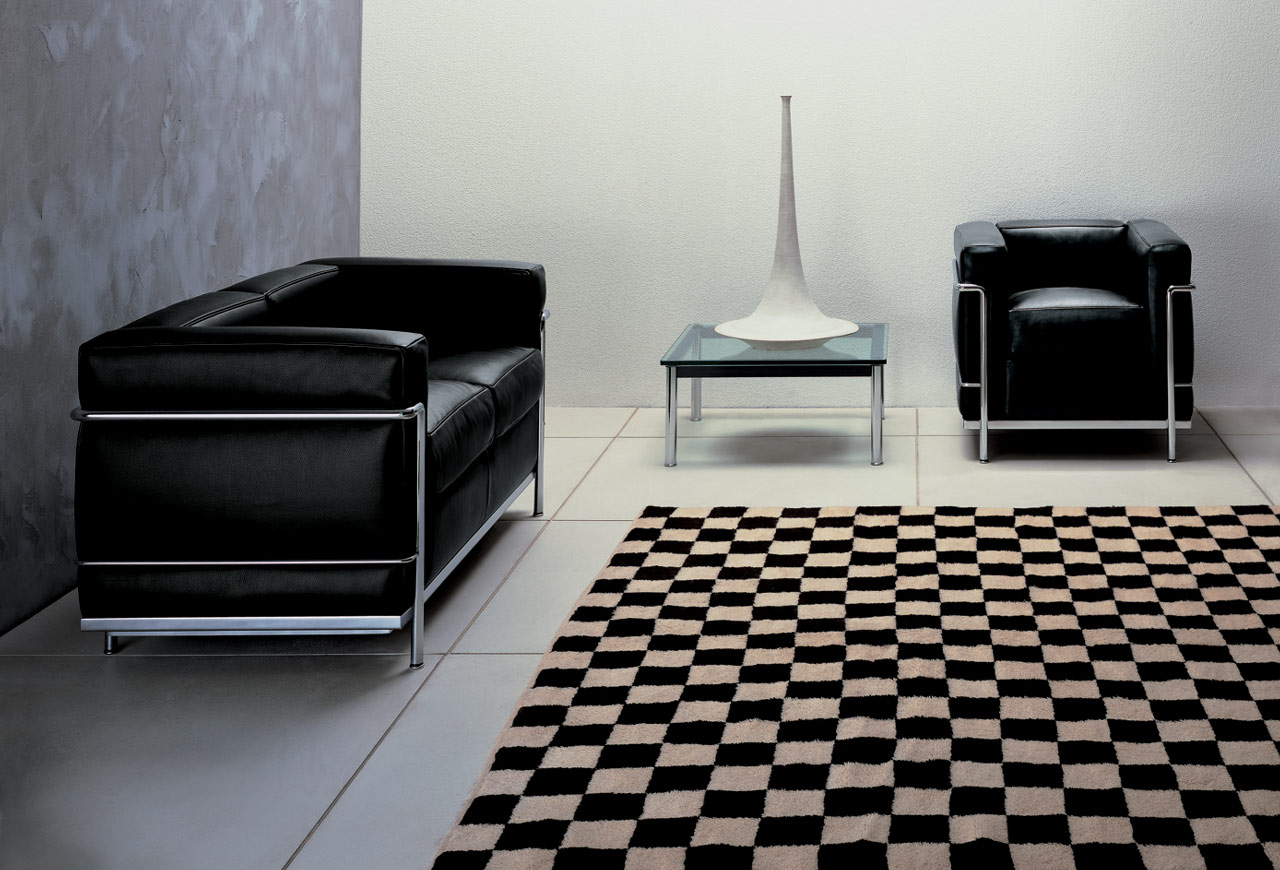 Schwarzer Cassina Sessel und Sofa "Grand Confort" mit Stahlrahmen in modernem Wohnzimmer.