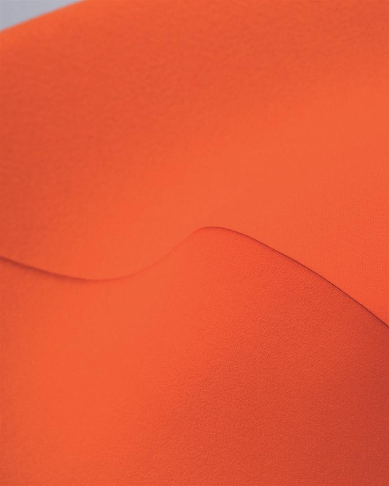 Detailaufnahme des orangefarbenen Stoffbezugs vom Bertoia Stuhl von Knoll International, moderner Designklassiker.